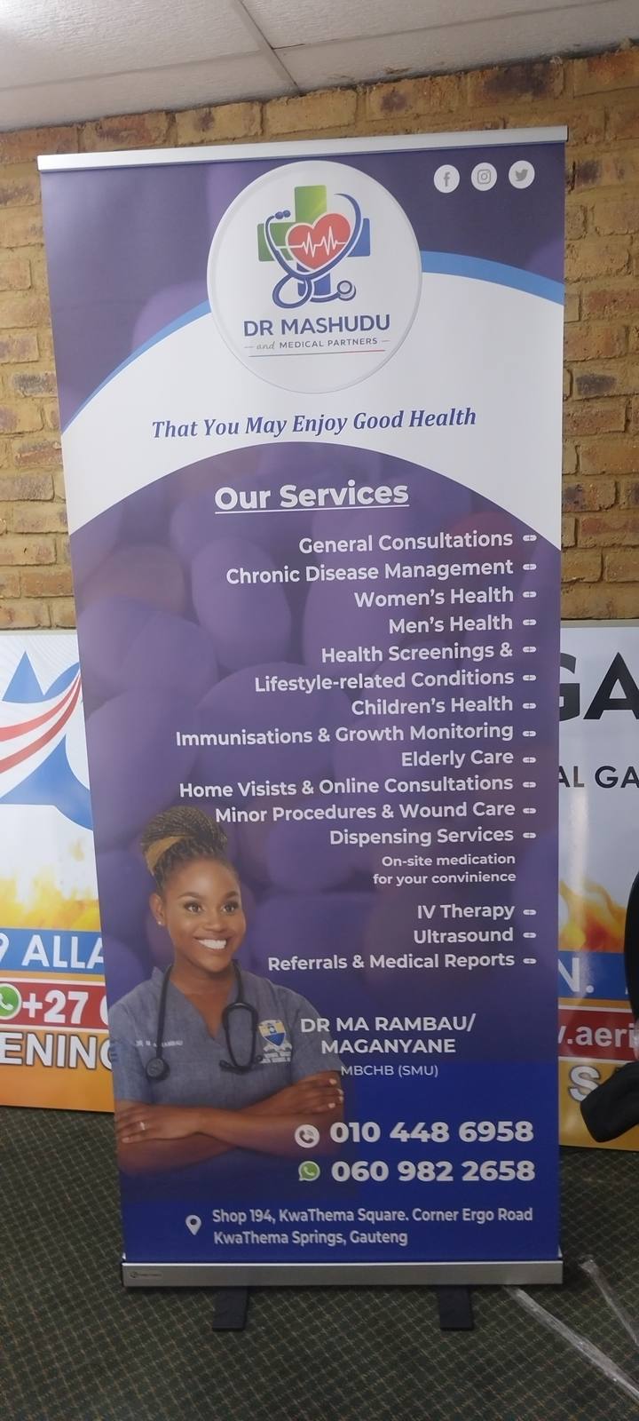 A purple Dr Mashudu roll-up banner with medical-service information and a portrait.