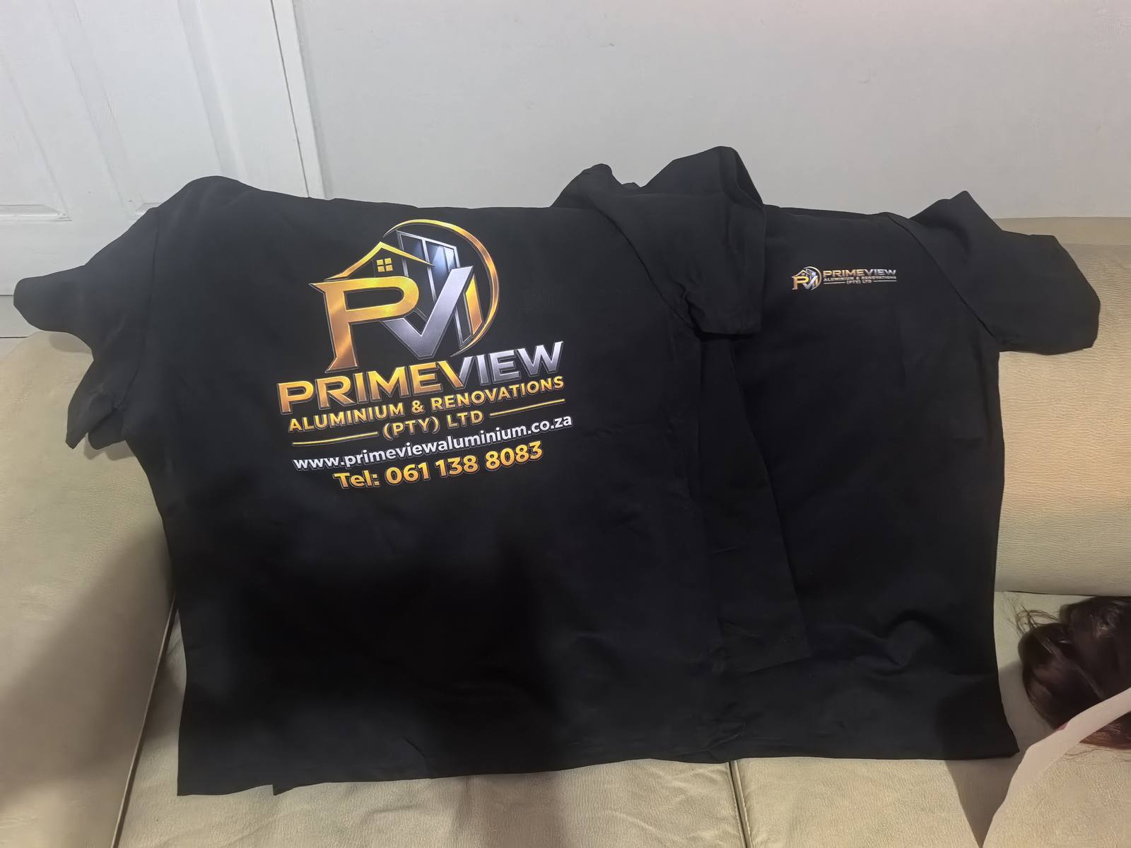 Two black shirts with large and small Primeview logo designs.
